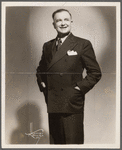 Julian Eltinge standing in striped suit with wide lapels and handkerchief, hands in pockets