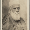 Photograph of man with beard in brimless hat and cloak