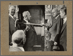 Photograph of Al Smith swinging sledgehammer at ceremonial start to Knickerbocker Village construction
