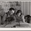 Fred Wilfang, rehabilitation client, goes over his farm plan with his wife. They have twenty hogs, ten milk cows, 250 chickens, a tractor, a bull and 500 quarts of canned goods. Black Hawk County, Iowa