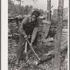 Evicted sharecropper chopping firewood. Butler County, Missouri
