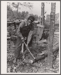 Evicted sharecropper chopping firewood. Butler County, Missouri