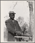 Evicted sharecropper fixes his axe. Butler County, Missouri