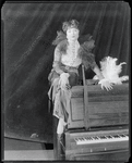 Publicity photograph of Helen Morgan sitting on a piano for the stage production Show Boat