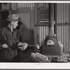 Assayer places crucible containing gold ore in furnace. El Dorado Canyon, Clark County, Nevada