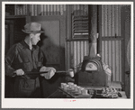 Assayer places crucible containing gold ore in furnace. El Dorado Canyon, Clark County, Nevada