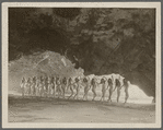 Chorus girls in bathing suits on the beach viewed from the mouth of a cave in the motion picture The Folly of Vanity