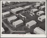 Woodville, California. FSA (Farm Security Administration) farm workers' community. Metal shelters are grouped about the utility building