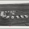 Woodville, California. FSA (Farm Security Administration) farm workers' community. Metal shelters are grouped around the central utility building