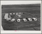 Woodville, California. FSA (Farm Security Administration) farm workers' community. Metal shelters are grouped around the central utility building