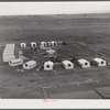 Woodville, California. FSA (Farm Security Administration) farm workers' community. Metal shelters are grouped around the central utility building