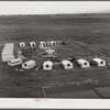 Woodville, California. FSA (Farm Security Administration) farm workers' community. Metal shelters are grouped around the central utility building