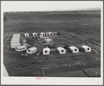 Woodville, California. FSA (Farm Security Administration) farm workers' community. Metal shelters are grouped around the central utility building