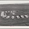 Woodville, California. FSA (Farm Security Administration) farm workers' community. Metal shelters are grouped around the central utility building