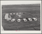 Woodville, California. FSA (Farm Security Administration) farm workers' community. Metal shelters are grouped around the central utility building