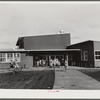 Woodville, California. FSA farm workers' community. The entrance at the central section of the community building. This high central section is the main auditorium. The rooms open off the auditorium and are used for school and various meetings