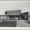 Woodville, California. FSA farm workers' community. The entrance at the central section of the community building. This high central section is the main auditorium. The rooms open off the auditorium and are used for school and various meetings