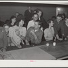 Woodville, California. FSA (Farm Security Administration) farm workers' community. Migrant agricultural workers eating hamburgers at the Saturday night dance