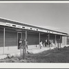 Woodville, California. FSA (Farm Security Administration) farm workers' community. Outside passageways are an important feature of the community building which is used as a school