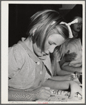 Tulare County, California. FSA (Farm Security Administration) farm workers' camp. Girls reading a copy of Popular mechanics