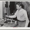 Tulare County, California. FSA (Farm Security Administration) farm workers' camp. Son of an agricultural worker making a model plane in the workshop