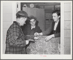 Tulare County, California. FSA (Farm Security Administration) farm workers' camp. Stamping a man's hand as he enters the movies