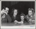 Woodville, California. FSA (Farm Security Administration) farm workers' community. Family group studying first aid lesson