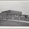 Woodville, California. FSA (Farm Security Administration) farm workers' community. Side view of the community building. Low rooms are used for school and various meetings. The higher central section is the main auditorium