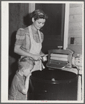 Woodville, California. FSA (Farm Security Administration) farm workers' community. Wife and son of an agricultural laborer who are permanent residents and live in one of the garden houses