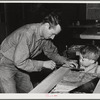 Eleven Mile Corner, Arizona. FSA (Farm Security Administration) farm workers' community. Agricultural worker and his son in the workshop