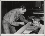 Eleven Mile Corner, Arizona. FSA (Farm Security Administration) farm workers' community. Agricultural worker and his son in the workshop