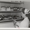 Eleven Mile Corner, Arizona. Cairns General Hospital, FSA (Farm Security Administration) farm workers' community. Nurse getting medicine from the storeroom