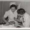 Resident doctor at the Cairns General Hospital attends boy who has been burned. FSA (Farm Security Administration) farm workers' community. Eleven Mile Corner, Arizona