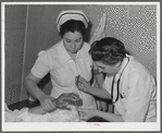 Resident doctor at the Cairns General Hospital attends boy who has been burned. FSA (Farm Security Administration) farm workers' community. Eleven Mile Corner, Arizona