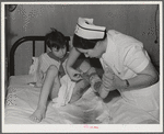 Eleven Mile Corner, Arizona. Cairns General Hospital, FSA (Farm Security Administration) farm workers' community. Nurse removing a patient's bandage