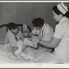 Resident doctor at the Cairns General Hospital changes dressing on boy who was badly burned. Eleven Mile Corner, Arizona