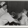Eleven Mile Corner, Arizona. Cairns General Hospital, FSA (Farm Security Administration) farm workers' community. Resident doctor dressing a burn