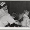 Eleven Mile Corner, Arizona. Cairns General Hospital, FSA (Farm Security Administration) farm workers' community. Resident doctor dressing a burn