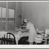 Eleven Mile Corner, Arizona. Cairns General Hospital, FSA (Farm Security Administration) farm workers' community. Nurse removing bandages from a patient