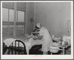 Eleven Mile Corner, Arizona. Cairns General Hospital, FSA (Farm Security Administration) farm workers' community. Nurse removing bandages from a patient