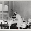 Eleven Mile Corner, Arizona. Cairns General Hospital, FSA (Farm Security Administration) farm workers' community. Nurse removing bandages from a patient