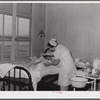 Eleven Mile Corner, Arizona. Cairns General Hospital, FSA (Farm Security Administration) farm workers' community. Nurse removing bandages from a patient