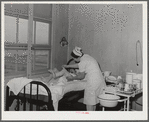 Eleven Mile Corner, Arizona. Cairns General Hospital, FSA (Farm Security Administration) farm workers' community. Nurse removing bandages from a patient