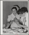 Eleven Mile Corner, Arizona. Cairns General Hospital, FSA (Farm Security Administration) farm workers' community. Resident doctor and nurse attending a patient