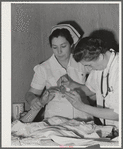 Eleven Mile Corner, Arizona. Cairns General Hospital, FSA (Farm Security Administration) farm workers' community. Resident doctor and nurse attending a patient