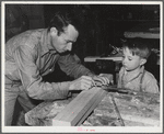 Eleven Mile Corner, Arizona. FSA (Farm Security Administration) farm workers' community. Agricultural worker and his son in the workshop