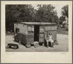 WPA (Works Progress/Work Projects Administration) worker and his wife sitting in front of their shack home on the Arkansas River near Webbers Falls, Oklahoma