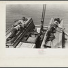 Negro stevedores sleeping on pile of lumber on bow of packet boat on Mississippi River below New Orleans, "El Rito"