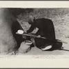 Spanish-American woman putting loaf of bread into oven, Taos County, New Mexico