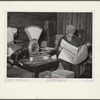 Farmer reading newspaper in feed and general produce store. Eufaula, Oklahoma